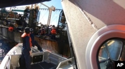 FILE - In this photo made available by the U.S. Coast Guard, guardsmen from the cutter James conduct a boarding of a fishing vessel in the eastern Pacific Ocean, on Aug. 6, 2022.
