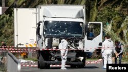 Investigators continue to work at the scene near the heavy truck that ran into a crowd at high speed killing scores who were celebrating the Bastille Day, July 14 national holiday on the Promenade des Anglais in Nice, France, July 15, 2016. 
