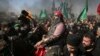 A Shiite re-enacts the events of Ashoura while Iranian and Iraqi Shiite Muslims mourn in a procession in southern Tehran, Iran on Oct. 12, 2016. 