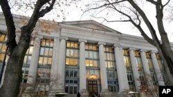Pejalan kaki berjalan di dekat pintu masuk ke sebuah gedung di Harvard Law School, di Cambridge, 5 Desember 2019, sebagai ilustrasi. (Foto: AP)