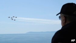 In this handout photo provided by the Turkish Presidency, Turkish President Recep Tayyip Erdogan watches fighter jets fly past during military exercises in Seferihisar, near Izmir, on Turkey's Aegean coast, June 9, 2022.