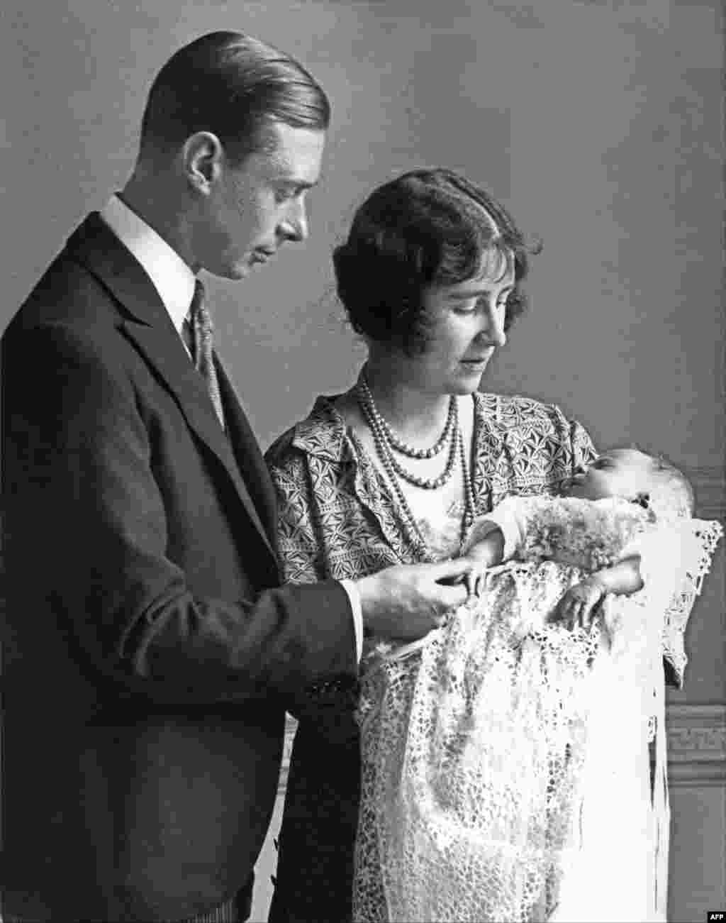 Lady Elizabeth Angela Marguerite Bowes-Lyon, the daughter of the 14th Earl of Strathmore, the Duchess of York (R) holds in 1926 in London her firstborn, Princess Elizabeth under the loving gaze of her husband, the Duke of York.