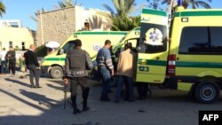 Emergency personnel and security forces stand next to ambulances outside the Swiss Inn hotel in the Egyptian town of El-Arish, in the Sinai peninsula, following an attack on the hotel Nov. 24, 2015.