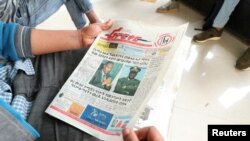 A man reads a newspaper with the pictures of Amhara state President Ambachew Mekonnen, killed in Bahir Dar, and of Army Chief of Staff Seare Mekonnen, who was shot by his bodyguard, on a street in Addis Ababa, Ethiopia, June 24, 2019.