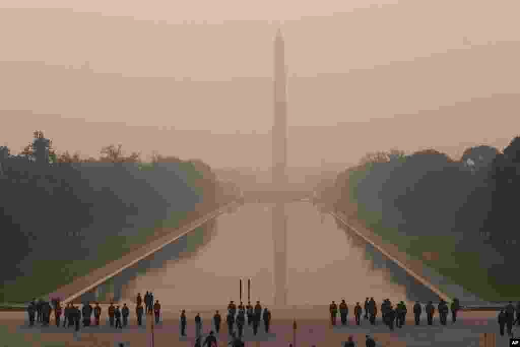 With the Washington Monument in the background and a thick layer of smoke, Marine Corps honor color guard rehearse, June 8, 2023, in Washington.