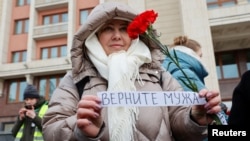 The wife of a mobilized Russian serviceman joins with other wives to demand the return of their husbands from Ukraine front, in Moscow, Feb. 3, 2024.