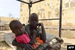 Anak-anak pengungsi yang melarikan diri dari kekerasan beristirahat di tempat tidur di halaman universitas Al-Jazira, yang diubah menjadi tempat penampungan sementara, di al-Hasahisa selatan Khartoum pada 8 Juli 2023. (Foto: AFP)