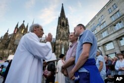 FILE - Same-sex couples take part in a public blessing ceremony in front of the Cologne Cathedral in Cologne, Germany, on Sept. 20, 2023.