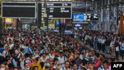 FILE - People wait for their train on platforms at the Chhatrapati Shivaji Terminus (CST) railway station Mumbai, India, April 19, 2023.