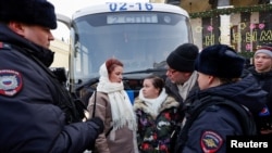 Women demanding the return of their husbands who joined the Russian armed forces involved in a military campaign in Ukraine, stand surrounded by police during a gathering in central Moscow, Feb. 3, 2024.