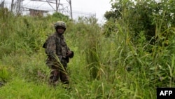 FILE - An M23 rebel looks on in Kibumba in eastern Democratic Republic of the Congo, Dec. 23, 2022. Clashes have intensified recently between the M23 and the Congolese army in eastern DRC. 