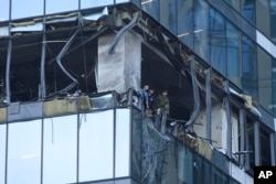 Para penyelidik memeriksa gedung pencakar langit di distrik bisnis Moskow City setelah serangan drone di Moskow, Minggu, 30 Juli 2023. (Foto: AP Photo)