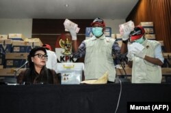 Wakil Komisioner Komisi Pemberantasan Korupsi (KPK) Basariah Panjaitan (kiri) bersama sejumlah penyidik KPK menunjukkan uang tunai yang disita dari anggota DPR menjelang pelaksanaan pemilihan umum, 28 Maret 2019. (Foto: Dessy Sagita/AFP)