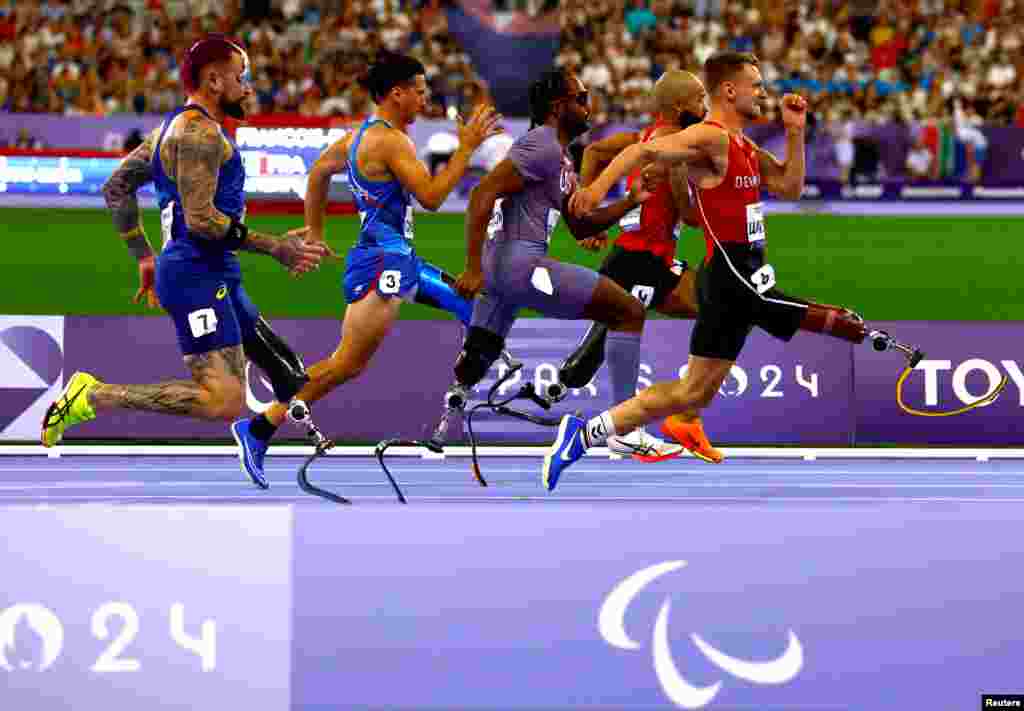 Alessandro Ossola of Italy, Leon Schaefer of Germany Desmond Jackson of United States, Daniel Wagner of Denmark and Vinicius Goncalves Rodrigues of Brazil compete in the athletics men's 100m T63 round 1 at the Stade de France, during the Paris 2024 Paralympics, Sept. 1, 2024.