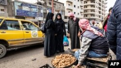 Seorang penjual truffle berbincang dengan pelanggan di sebuah pasar di Raqa, Suriah, pada 14 Maret 2023. Sebanyak 14 pencari truffle tewas akibat ledakan ranjau darat yang ditanam ISIS di gurun di Raqa. (Foto: AFP/Delil Souleiman)