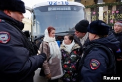 Members of the women's movement "Way Home," demanding the return of their husbands who joined the Russian armed forces involved in a military campaign in Ukraine, stand surrounded by police officers during a gathering in central Moscow, Feb. 3, 2024.