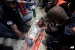 Palestinians rescue a wounded girl from under the rubble of a destroyed building following an Israeli airstrike in Khan Younis refugee camp, southern Gaza Strip, Nov. 7, 2023.
