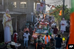 Potret Perdana Menteri India Narendra Modi berukuran raksasa dipajang di sepanjang rute saat kandidat Partai Bharatiya Janata (BJP) Tamilisai Soundararajan mengendarai kendaraan di Chennai, 14 April 2024.
