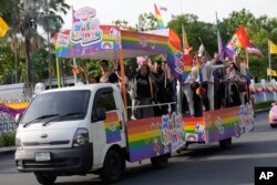 Para pendukung pernikahan sesama jenis mengibarkan bendera di gedung pemerintah di Bangkok, Thailand, Selasa, 18 Juni 2024, merayakan diloloskannya RUU kesetaraan dalam pernikahan. (AP/Sakchai Lalit)