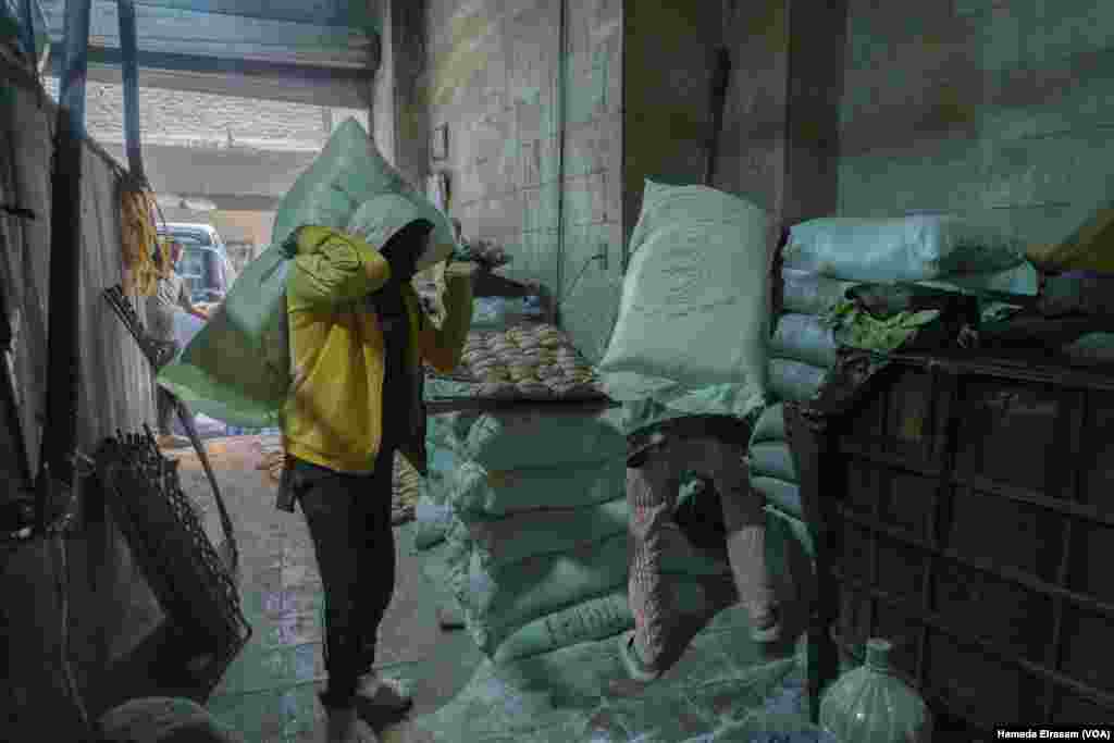 Wheat factory workers deliver sacks of subsidized flour to a bakery. Egypt, a top global wheat importer, says half of the 18 million tons of the grain that it consumes each year goes to subsidized bread. Cairo, Egypt, June 24, 2024. (Hamada Elrasam/VOA)
