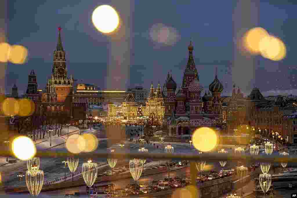 Menara Spasskaya, Lapangan Merah, Pusat Perbelanjaan GUM, dan Katedral St. Basil didekorasi untuk menyambut liburan Natal dan Tahun Baru, terlihat dari jendela Hotel Baltschug Kempinski Moskow, di Moskow, Rusia.