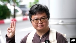 Arnon Nampa memberi hormat tiga jari, simbol perlawanan, usai berbicara kepada media setibanya di Pengadilan Kriminal Selasa, 26 September 2023. (Foto: AP)