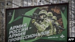 FILE - A photograph taken Oct. 24, 2022 shows a poster displaying Russian soldiers with a slogan reading 'Army of Russia - Army of professionals' decorating a street in Moscow.