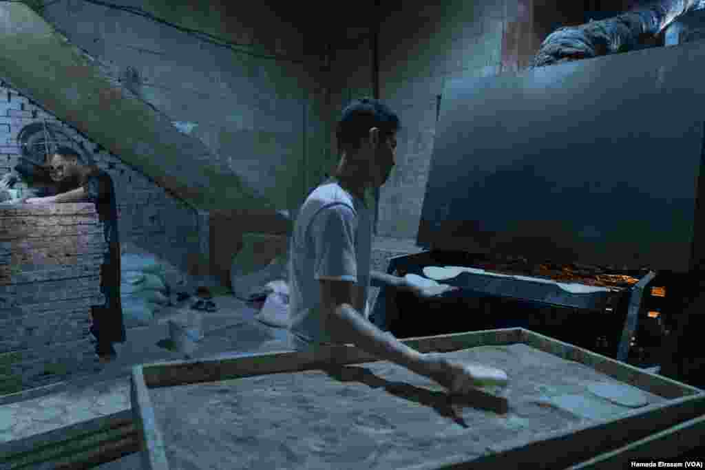 Youssef and Mostafa, friends from Upper Egypt, work in a subsidized bakery for about $4 a day. “The new price of bread is unbearable for many people,” says Youssef. “We’re lucky to receive some free loaves from work.” Cairo, Egypt, June 24, 2024. (Hamada Elrasam/VOA)