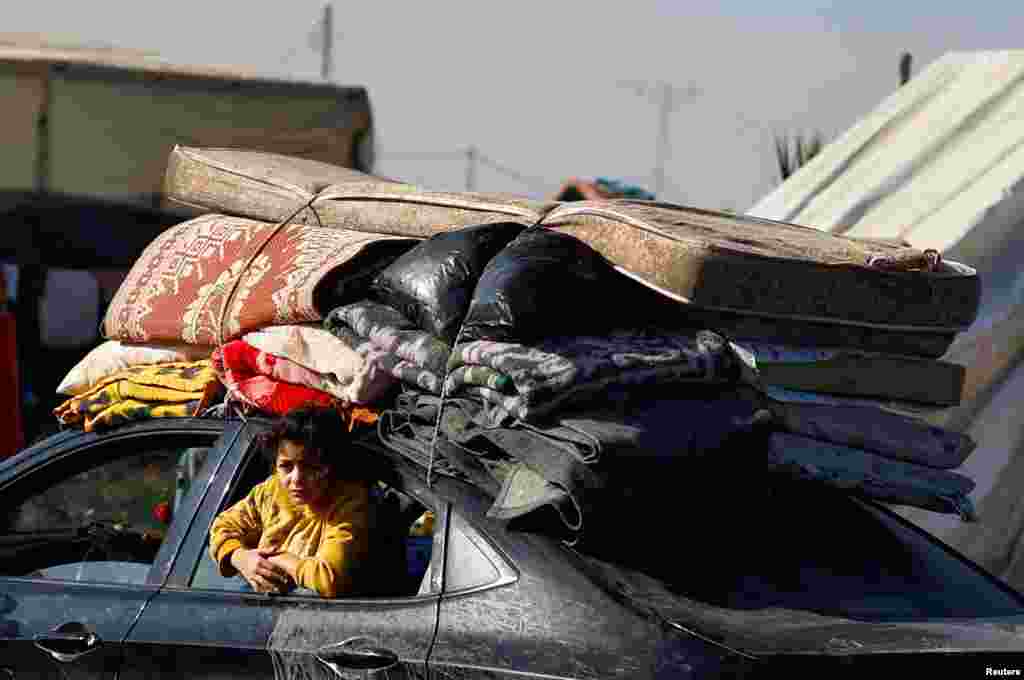 Seseorang melihat keluar dari jendela mobilnya, saat warga Palestina mengungsi dan meninggalkan rumah mereka akibat serangan Israel, berlindung di tenda kamp di Rafah, Jalur Gaza selatan.
