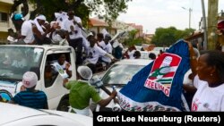 Um grupo de apoiantes do MDM, na oposição, passa numa viatura por apoiantes do partido Frelimo, no poder, durante a campanha para as eleições autárquicas, na capital Maputo, a 17 de novembro de 2013. REUTERS/Grant Lee Neuenburg