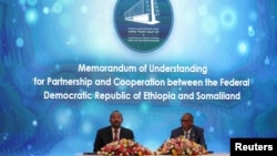 Somaliland President Muse Bihi Abdi, right, and Ethiopia’s Prime Minister Abiy Ahmed attend the signing of the Memorandum of Understanding that allows Ethiopia to use a Somaliland port, in Addis Ababa, Ethiopia, Jan. 1, 2024. 