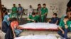 Para staf medis di Rumah Sakit Ahli Arab berduka di dekat jenazah rekan mereka yang dibungkus kafan yang terbunuh selama pemboman Israel di kamp pengungsi Shati, di lokasi rumah sakit di Kota Gaza (14/6).