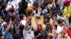 Warga negara Myanmar yang tinggal di Thailand memegang foto mantan pemimpin Myanmar Aung San Suu Kyi selama protes yang menandai peringatan dua tahun pengambilalihan militer Myanmar, di Bangkok, Thailand, 1 Februari 2023. (Foto: AP)