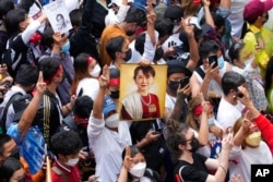 Warga negara Myanmar yang tinggal di Thailand memegang foto mantan pemimpin Myanmar Aung San Suu Kyi selama protes yang menandai peringatan dua tahun pengambilalihan militer Myanmar, di Bangkok, Thailand, 1 Februari 2023.