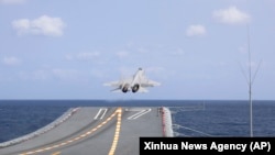 FILE - In this photo released by China's Xinhua News Agency, a J-15 Chinese fighter jet takes off from the Shandong aircraft carrier during military exercises around Taiwan by the Eastern Theater Command of the Chinese People's Liberation Army, April 9, 2023.