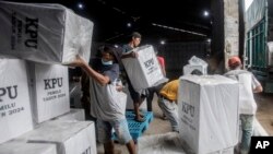 Para pekerja memuat kotak suara ke dalam truk untuk didistribusikan ke TPS menjelang pemilu di Medan, Sumatra Utara, 12 Februari 2024. (Foto: AP)
