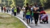 FILE — Migrants walk through Villa Comaltitlan, Chiapas state, southern Mexico, Dec. 27, 2023, heading toward the U.S. border. In a letter to President Joe Biden and congressional leaders, some state leaders say they are unable to cope with the volume of immigrants.