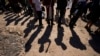 FILE - Migrants wait to be processed by U.S. officials after crossing the Rio Grande and entering the U.S. from Mexico, in Eagle Pass, Texas, Oct. 19, 2023. U.S. President Joe Biden and presidential candidate Donald Trump will visit the U.S./Mexico border soon — but separately.