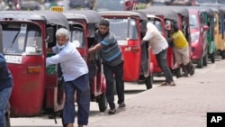 FILE - Auto rickshaw drivers line up to buy gas near a fuel station in Colombo, Sri Lanka, April 13, 2022. 