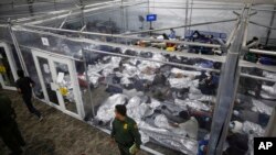 FILE - Children lie inside a pod at the main detention center for unaccompanied children in the Rio Grande Valley run by U.S. Customs and Border Protection, in Donna, Texas, March 30, 2021.
