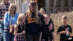 Children and a woman depart the reunification center at the Woodmont Baptist church after a school shooting in Nashville, Tennessee, March 27, 2023.