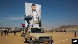 Borci Huta nose poster sa likom lidera pokreta Huti, Abdelom Malekom al-Hutijem, tokom mitinga podrške za Palestince u Gazi i protiv vazdušnih udara predvođenih SAD na Jemen, u Sani, Jemen, 29. januara 2024.