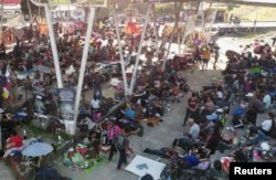 Migrants traveling in a caravan rest in a public square before continuing their journey through Mexico, in Huixtla, Mexico, Dec. 25, 2023.