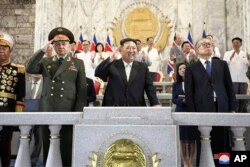 지난 7월 평양에서 열린 한국전 정전 70주년 열병식에서 김정은 북한 국무위원장이 세르게이 쇼이구 러시아 국방장관, 리훙중 중국 전인대 상임 부위원장과 함께 나란히 주석단에 앉았다.