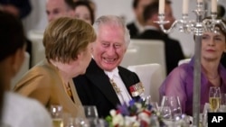 Raja Inggris Charles III berbicara dengan mantan Kanselir Jerman Angela Merkel dalam acara jamuan makan malam di Bellevue Palace, Berlin, pada 29 Maret 2023. (Foto: Bernd von Jutrczenka/Pool via AP)