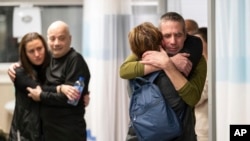 Fernando Marman (kanan) dan Louis Har (kedua dari kiri), memeluk kerabatnya setelah diselamatkan dari tempat penyanderaan mereka di Jalur Gaza, di Sheba Medical Center, Ramat Gan, Israel, 12 Februari 2024.
