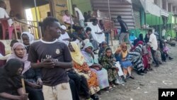FILE - People from states of Khartoum and al-Jazira, displaced by the ongoing conflict in Sudan between the army and paramilitaries, wait to receive aid from a charity organisation in Gedaref on Dec. 30, 2023. 
