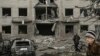 Warga berjalan di depan gedung yang hancur akibat serangan Rusia di Sloviansk, Ukraina pada 27 Maret 2023. (Foto: AFP)