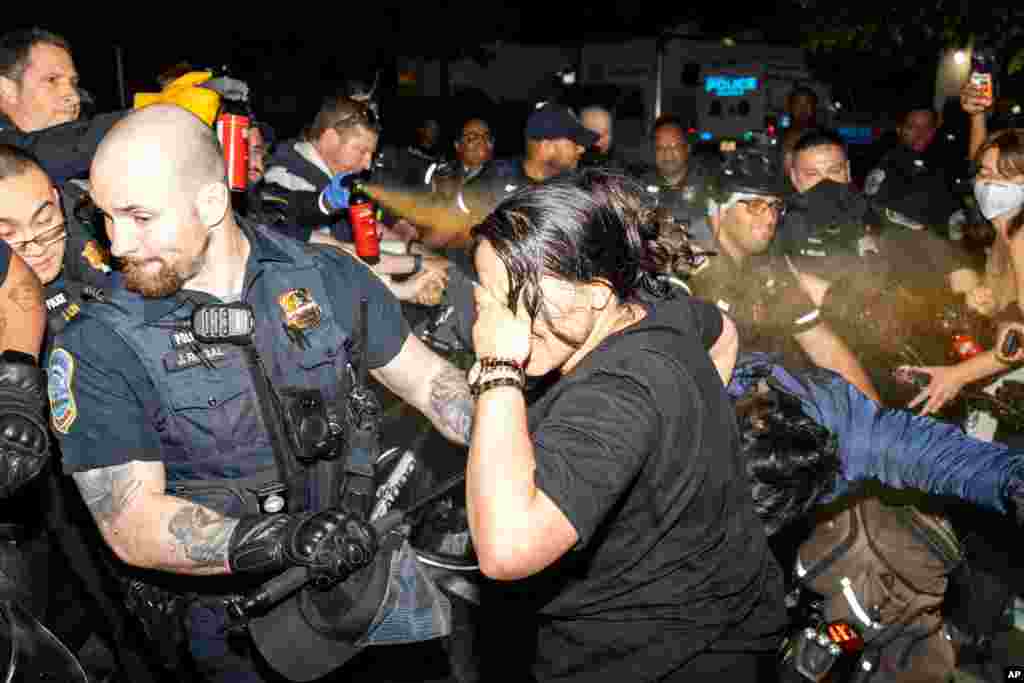 Polisi Metropolitan menyemprotkan cairan merica ke pengunjuk rasa di Universitas George Washington, Washington, Rabu pagi, 8 Mei 2024. Polisi merobohkan tenda-tenda perkemahan pro-Palestina di Universitas George Washington dan menangkap para demonstran, beberapa jam setelah puluhan orang berbaris ke rumah rektor sekolah tersebut. (Sage Russell, GW Hatchet via AP)