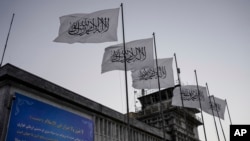 FILE - Taliban flags fly at the airport in Kabul, Afghanistan, Sept. 9, 2021. Two years on from the Taliban takeover of Afghanistan, the U.S. is easing rules that could allow commercial airlines to fly over the country.